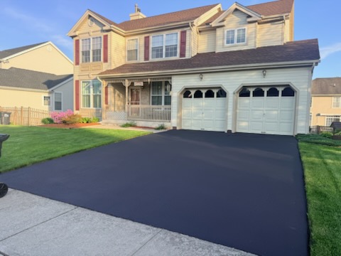 Jet-black sealcoated driveway leading to two-car garage on colonial home