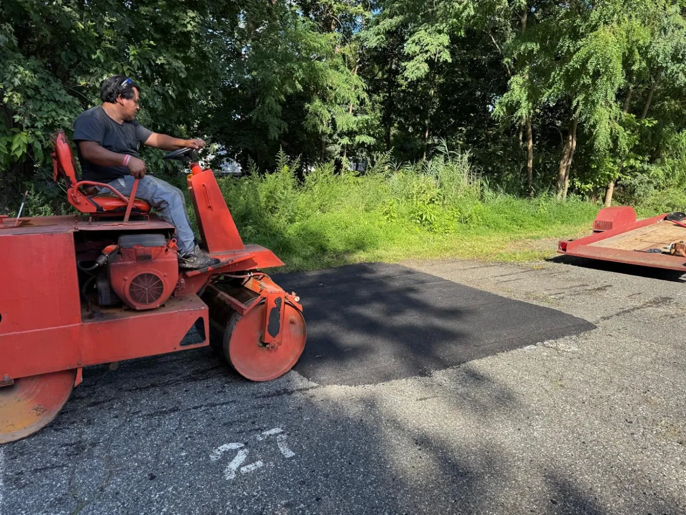 Roller compacting fresh asphalt patch repair