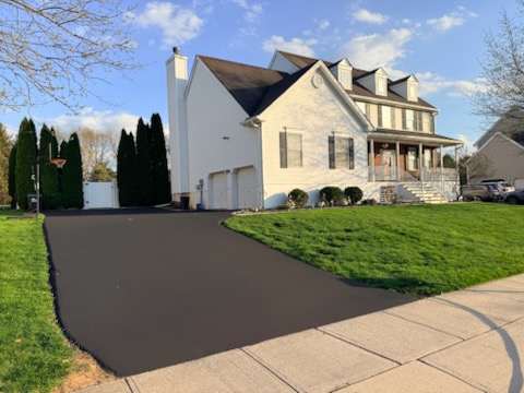 Same driveway freshly sealcoated jet-black with crisp edges