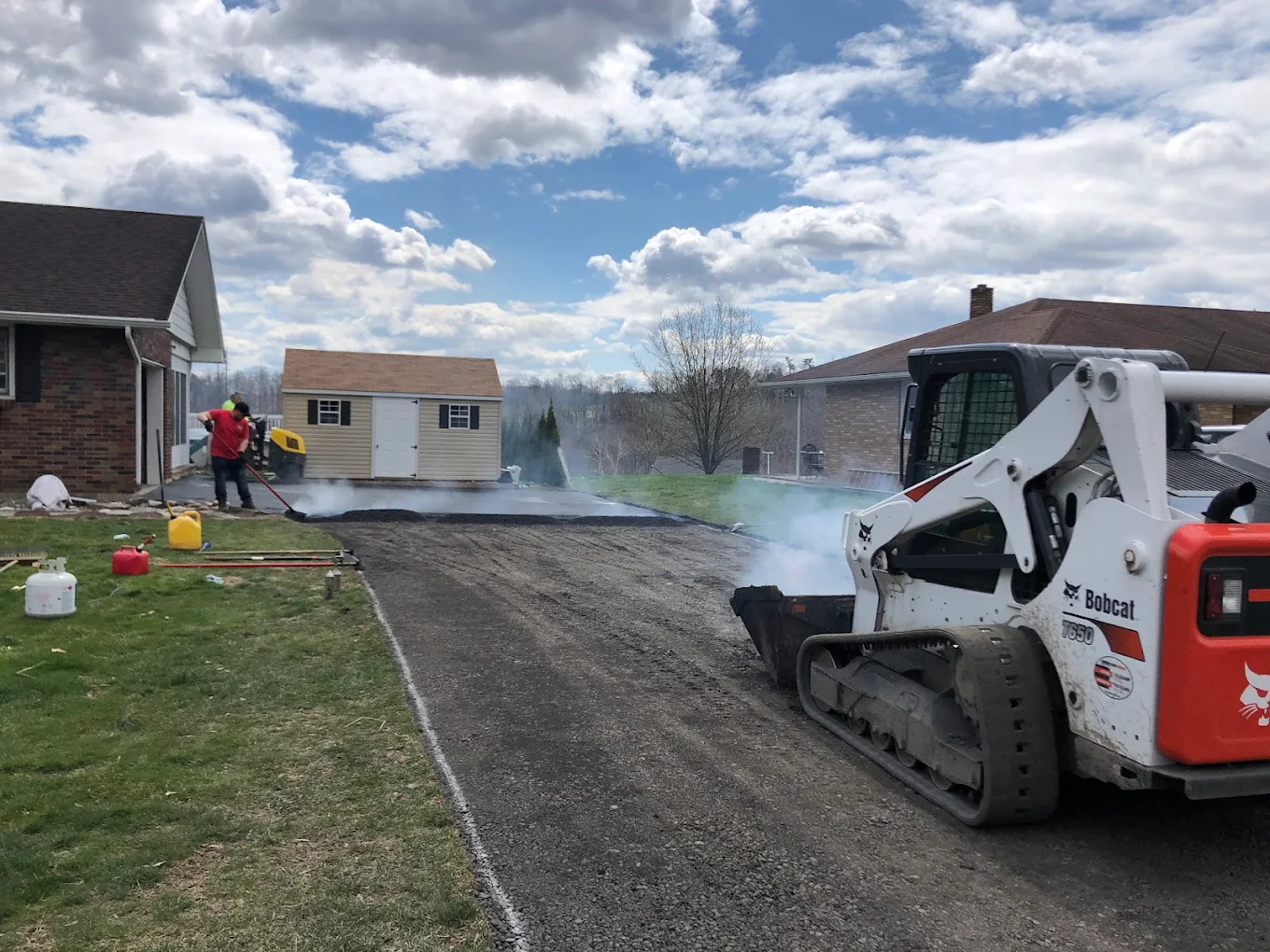 New asphalt paving in progress with Bobcat skid steer