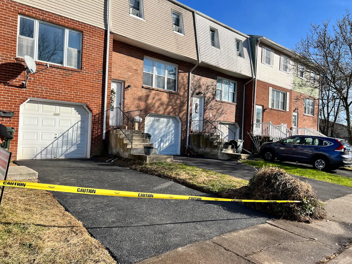 Townhouse driveway sealcoating with caution tape
