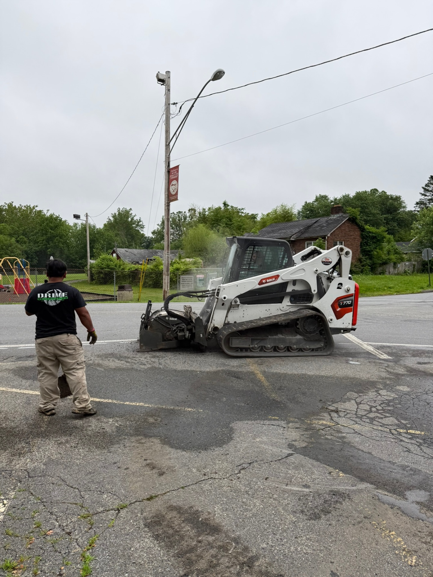 Drive Sealcoating crew running a Bobcat T770 with milling head on a parking lot